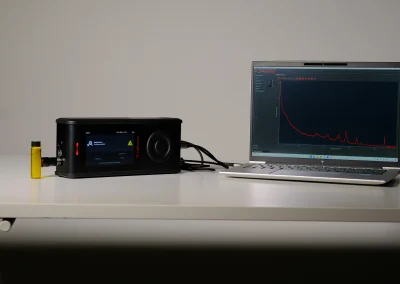 RG spectrometer connected to laptop displaying Raman spectrum analysis